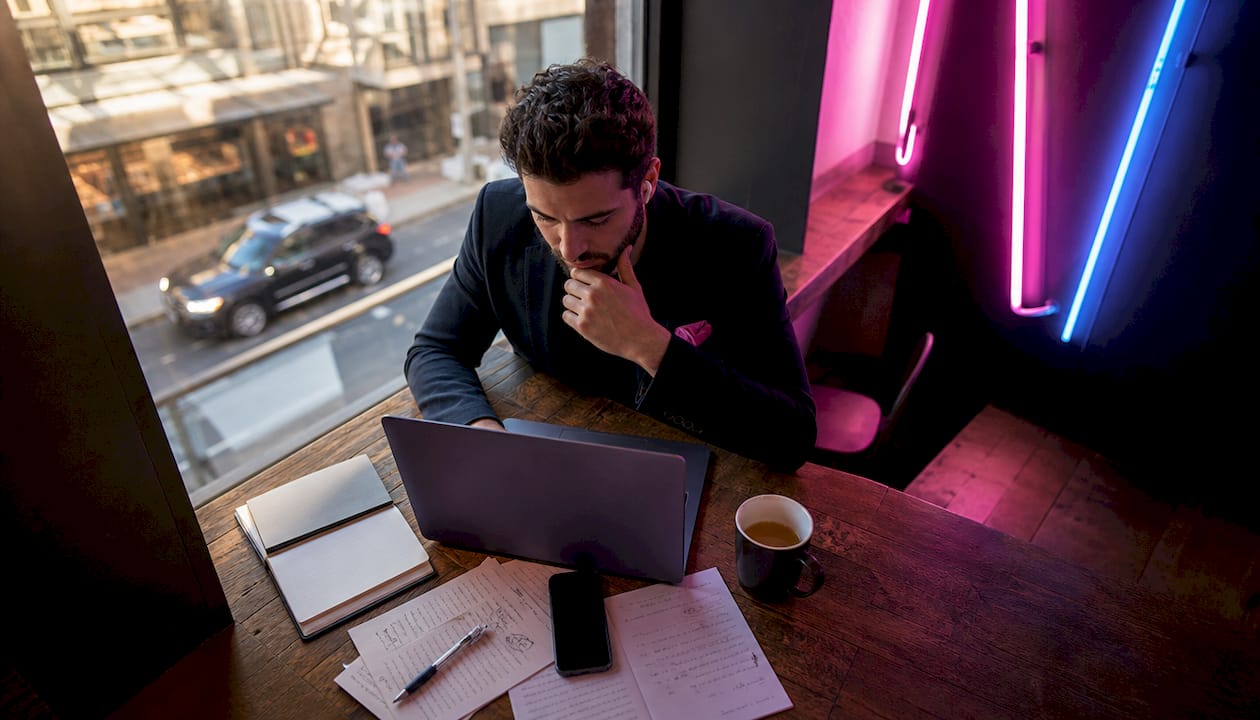 Un homme au bureau analyse les différences entre une application mobile et un site internet.