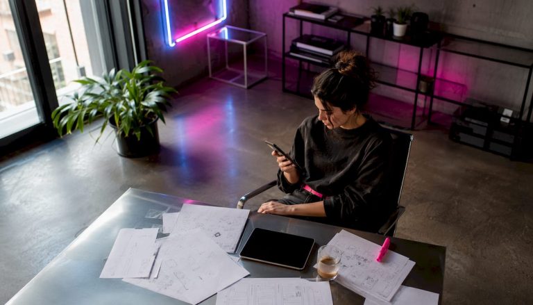 Une femme consulte attentivement une application de commerce en ligne sur son smartphone.