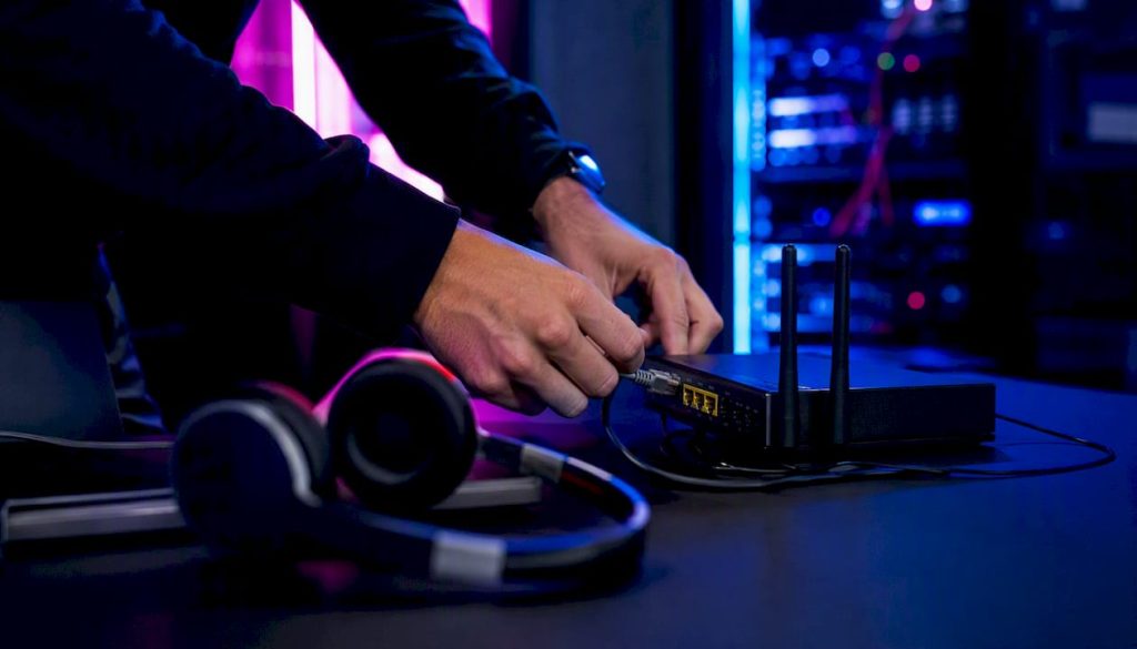 Des mains branchent un câble réseau pour réaliser des tests de sécurité informatique.